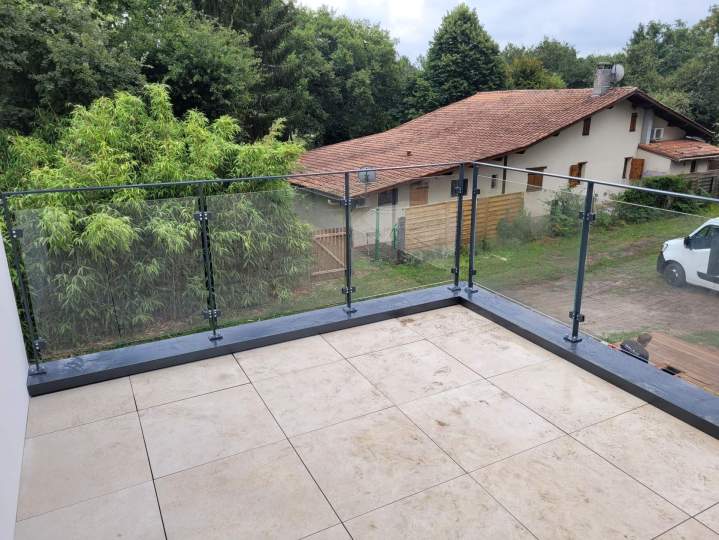Garde-corps vitré sur structure acier dans les Landes, finition épurée pour escalier intérieur.